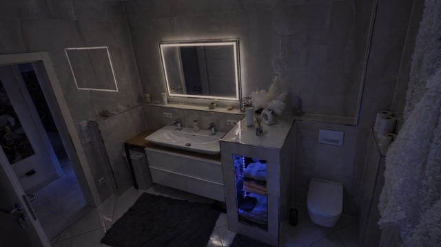 Badezimmer mit beleuchtetem Spiegel und Doppelwaschplatz