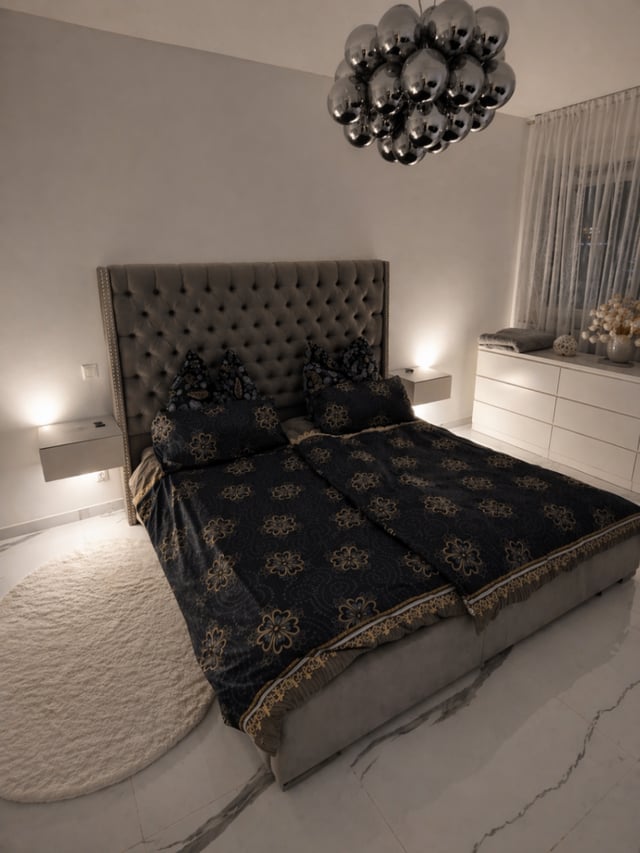 Schlafzimmer der Designer-Wohnung mit gepolstertem Bett und Designer-Leuchte