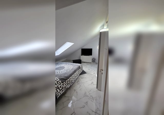Schlafzimmer mit Marmorboden und Smart-TV