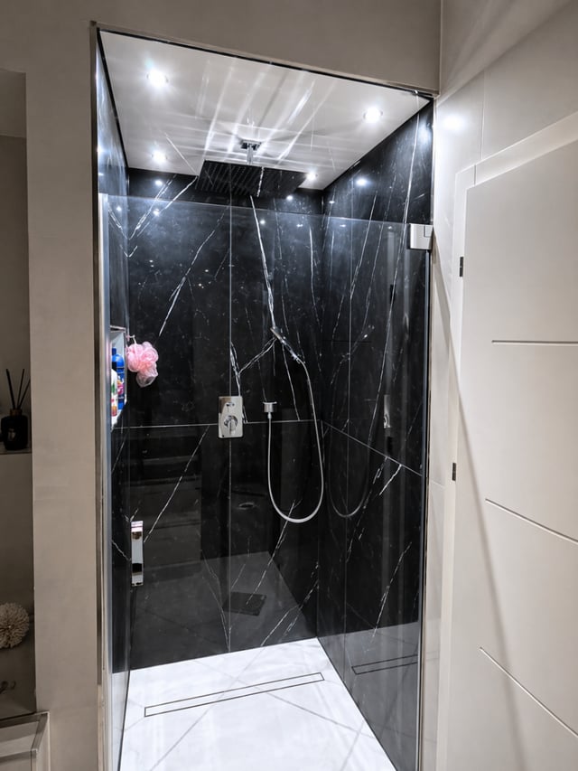 Große Regendusche mit dunklem Marmor im Badezimmer